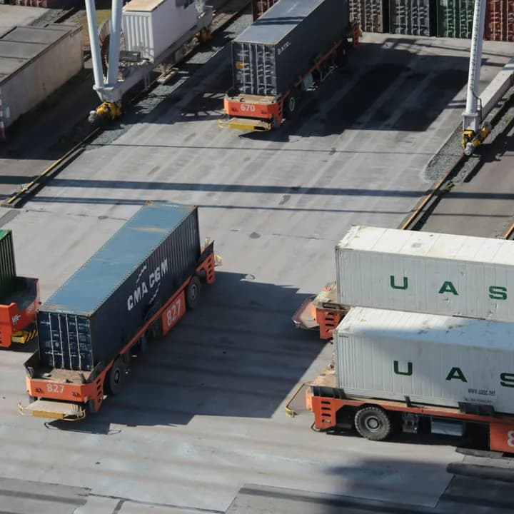 Seecontainer und Terminalzugmaschinen auf einem Logistikgelände.